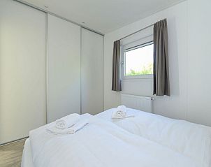 Slaapkamer met groot raam en veel licht in Vakantiehuis Hart van Zeeland, Heinkenszand.