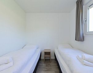 Twee comfortabele bedden in slaapkamer van Vakantiehuis Hart van Zeeland, Heinkenszand.