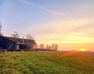 Prachtig uitzicht op weide bij zonsondergang vanuit Vakantiehuisje in Wolphaartsdijk, Zeeland.