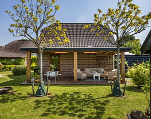 Ruim terras met zitgedeelte bij Vakantiehuis Haus Anni in Hansweert, Zuid-Beveland, omgeven door groen.