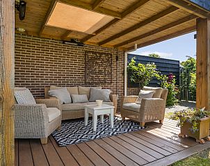 Overdekte veranda met comfortabele zitjes bij Vakantiehuis Haus Anni in Hansweert, Zuid-Beveland.