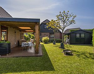 Groene tuin met terras en schuur bij Vakantiehuis Haus Anni in Hansweert, Zuid-Beveland, ideaal voor ontspanning.