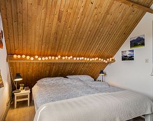Knusse slaapkamer met houten plafond in Vakantiehuis Haus Anni, Hansweert, Zuid-Beveland.