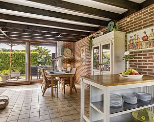 Eetruimte met open zicht op de tuin in Vakantiehuis Haus Anni, Hansweert, Zuid-Beveland.