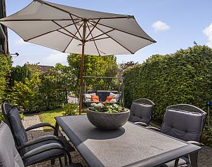 Terras met parasol en comfortabele stoelen bij Vakantiehuis Haus Anni, Hansweert, Zuid-Beveland.