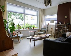 Gezellige woonkamer van Vakantiehuisje in Lewedorp, Zuid-Beveland, met uitzicht op de natuur en comfortabele zitruimte.