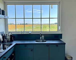 Keukenraam met uitzicht op velden bij Vakantiehuis in Lewedorp, geniet van de natuur in Zuid-Beveland, Zeeland.