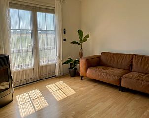 Gezellige woonkamer met leren bank in Vakantiehuis in Lewedorp, ideaal voor ontspanning in Zuid-Beveland, Zeeland.