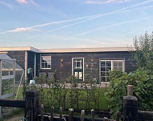 Buitenzijde van Vakantiehuis in Lewedorp bij zonsondergang, serene omgeving in Zuid-Beveland, Zeeland.