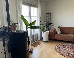 Woonkamer met planten en bank in Vakantiehuis in Lewedorp, huiselijke sfeer in Zuid-Beveland, Zeeland.