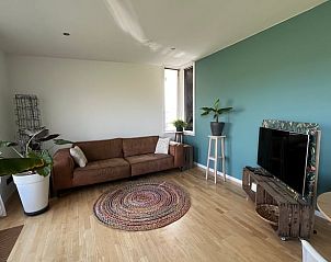 Lichte woonkamer met ronde tapijt in Vakantiehuis in Lewedorp, gezellige sfeer in Zuid-Beveland, Zeeland.