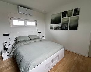 Slaapkamer met kunst aan de muur in Vakantiehuis in Lewedorp, stijlvolle inrichting in Zuid-Beveland, Zeeland.