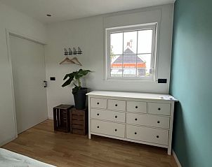 Slaapkamer met uitzicht op tuin in Vakantiehuis in Lewedorp, rustgevende omgeving in Zuid-Beveland, Zeeland.