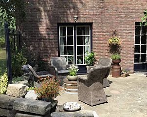 Rustieke buitenruimte bij Vakantiehuisje in Vlake, Zuid-Beveland met comfortabele stoelen.