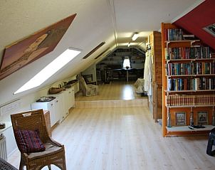 Ruime binnenruimte in Vakantiehuisje in Vlake, Zuid-Beveland met houten vloer.