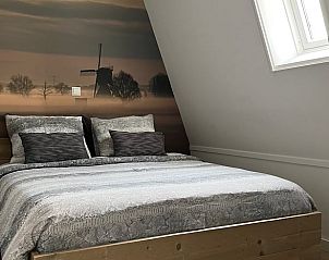 Sfeervolle slaapkamer in vakantiehuis Streefkerk, Alblasserwaard, met uitzicht op molen.