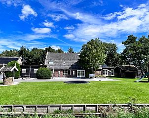 Grote tuin met speeltoestellen bij vakantiehuis Streefkerk, Zuid-Holland.