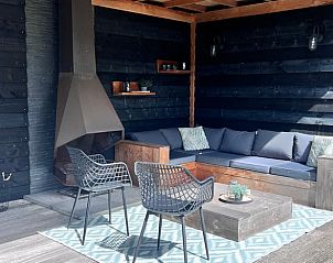 Gezellige buitenruimte met open haard in Vakantiehuisje in Streefkerk, ideaal voor avonden.