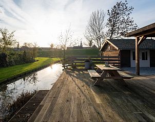 Houten terras met picknicktafel bij Vakantiehuisje in Streefkerk, perfect voor buitenmaaltijden.