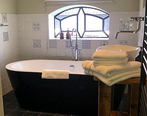 Luxe badkamer in Vakantiehuis in Stolwijk met vrijstaand bad en handdoeken, Alblasserwaard, Zuid-Holland.