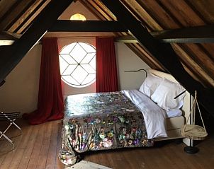 Sfeervolle slaapkamer met houten balken in Vakantiehuis in Stolwijk, Alblasserwaard, Zuid-Holland.