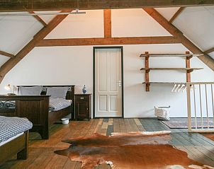 Ruime slaapkamer met houten balken in vakantiehuis Stolwijk, Alblasserwaard, Zuid-Holland.