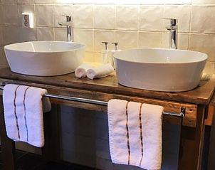 Moderne badkamer met dubbele wastafel in Huisje in Stolwijk, vakantiehuis in Alblasserwaard.
