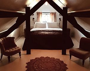 Romantische slaapkamer met stoelen in Huisje in Stolwijk, vakantiehuis in Zuid-Holland.