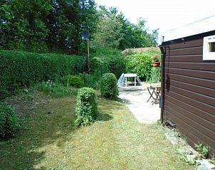 Verzorgde tuin van Het Zomernest in Ouddorp met stenen terras en tuinmeubilair.