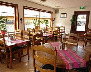 Lichte eetruimte in Pension Ouddorp, een gastvrije bed and breakfast in Ouddorp, Zuid-Holland, met uitzicht op de groene omgeving.