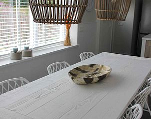 Esszimmer des Ferienhauses ZH330 in Ouddorp mit stilvollem Holztisch und moderner Beleuchtung.