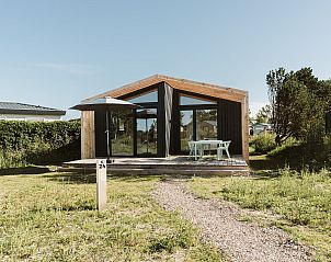 Scheunenferienhaus in Ouddorp, Goeree-Overflakkee mit moderner Veranda und grner Umgebung.