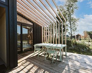 Sonnige Terrasse am Ferienhaus Barn in Ouddorp, Sdholland, mit Holzpergola.