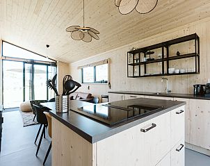 Offene Kche und Essbereich in einem Ferienhaus in Ouddorp, Sdholland, mit modernem Design.