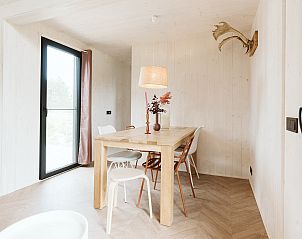 Eetgedeelte in Scandic vakantiehuis in Ouddorp, met houten tafel en moderne stoelen.