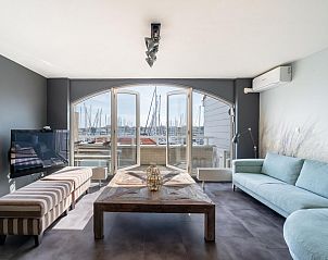 Lichte woonkamer in vakantiehuis De Brouwersdam in Ouddorp, Goeree-Overflakkee, met uitzicht op de jachthaven en moderne inrichting.