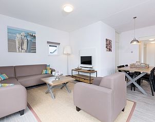 Gemtliches Wohnzimmer von Bungalow 6C in Ouddorp, Goeree-Overflakkee, Sdholland, mit bequemer Sitzecke und modernem Essbereich.