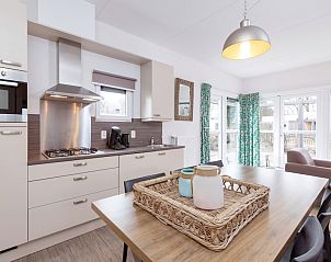 Moderne Kche im Bungalow 6C, Ouddorp, Goeree-Overflakkee, Sdholland, mit heller Einrichtung und Blick auf die Terrasse.