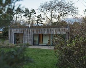 Vacation home in Ouddorp surrounded by nature on Goeree-Overflakkee, South Holland, with a modern wooden facade and spacious garden.