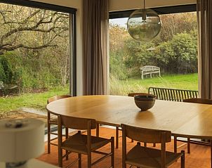 Cozy dining area in vacation home in Ouddorp with a view of the green garden, located in Ouddorp, Goeree-Overflakkee, South Holland.