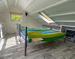 Lichte slaapkamer op zolder van VZ990 Vakantiewoning in Ouddorp met kleurrijk beddengoed in Zuid-Holland.