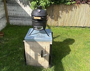 Barbecue in de tuin van VZ990 Vakantiewoning in Ouddorp, perfect voor zomerse avonden in Zuid-Holland.