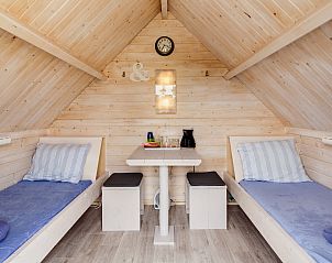 Gemtlicher Innenbereich des Kampeerhut 't Gorsje in Ouddorp mit bequemen Betten und Holzmbeln.