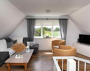 Moderne woonkamer van ZH022 vakantiehuis in Ouddorp met tv en gezellige inrichting, ideaal voor ontspanning in Zuid-Holland.