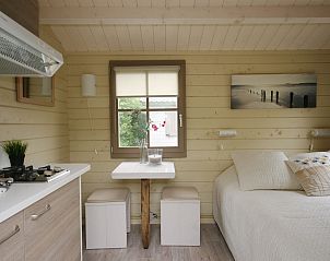 Gemtliches Interieur des Camping Chalet de Zeester in Ouddorp mit bequemem Bett und Kche, perfekt fr einen gemtlichen Urlaub.