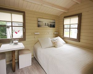 Schlafzimmer im Camping Chalet de Zeester in Ouddorp mit groen Fenstern und komfortabler Einrichtung fr einen erholsamen Urlaub.