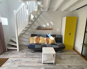 Modernes Wohnzimmer im Ferienhaus VZ991 in Ouddorp, mit hellen Mbeln und Treppe.