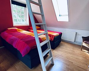 Zolderkamer met kleurrijke bedden in VZ757 Luxe vakantiehuis in Ouddorp, gelegen in Goeree-Overflakkee, Zuid-Holland.