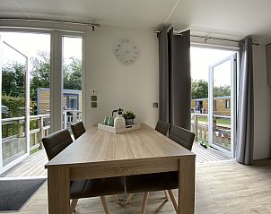 Dining area in Mobil home Strandloper, Ouddorp, overlooking terrace and garden, perfect place for family dinners.
