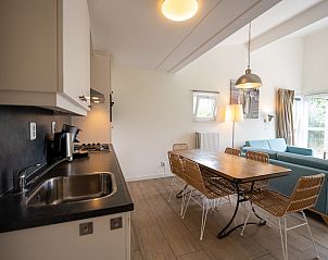 Gezellige woonkamer van Hondenbungalow 6C in Ouddorp, Goeree-Overflakkee, Zuid-Holland met open keuken en comfortabele zithoek.